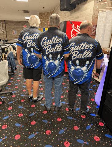 Back view of the Gutter Balls team’s blue and black bowling shirts, featuring the team name, bowling balls, and pins.